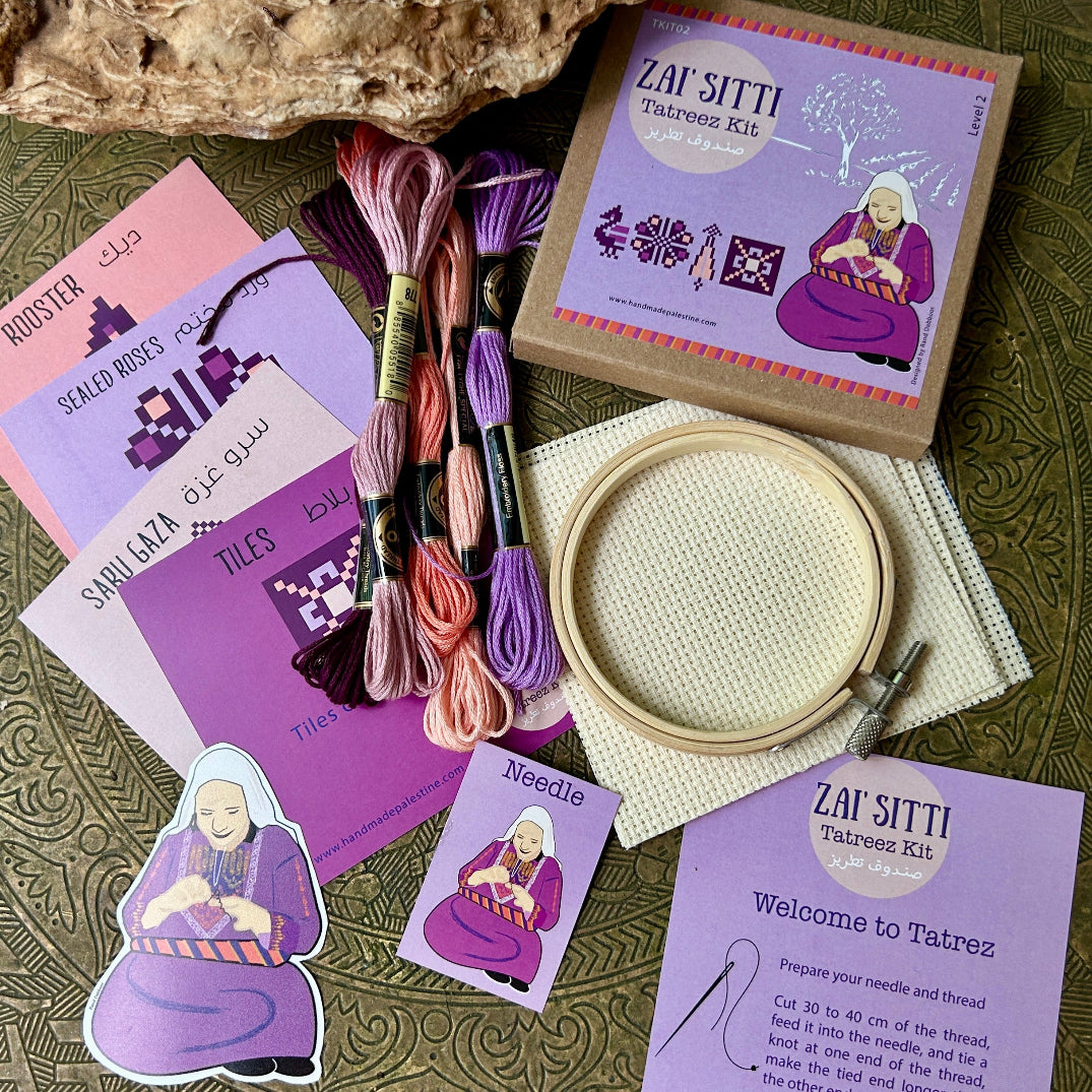 Embroidery kit with threads, hoop, and cards on a textured surface