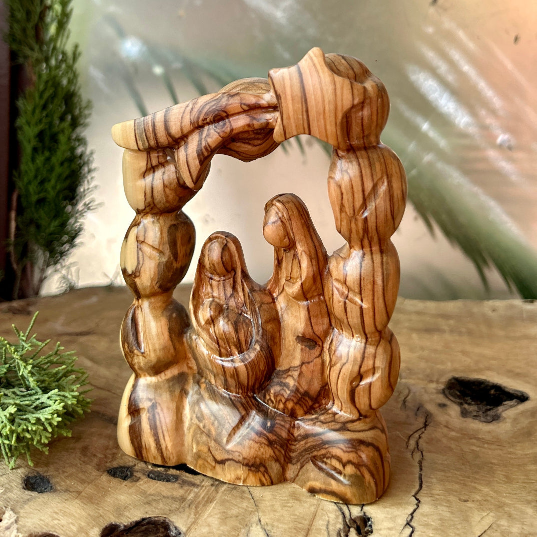 Wooden nativity scene sculpture on a wooden surface with a blurred background