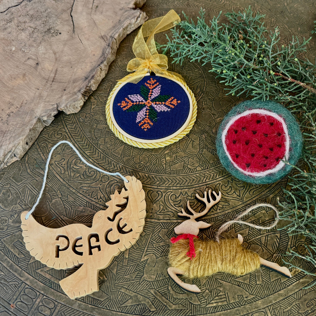 Decorative Christmas ornaments on a textured surface with greenery