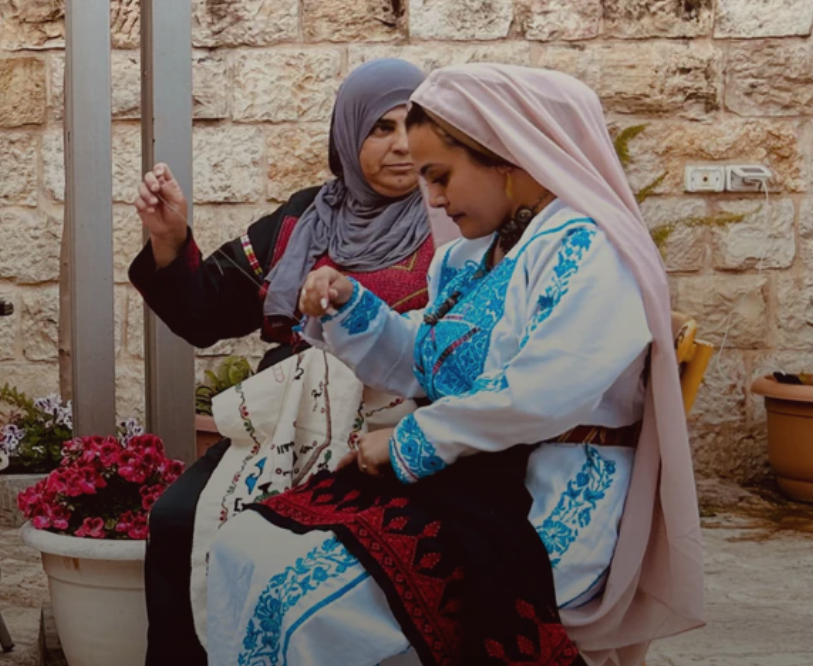 Two Palestinian women doing tatreez embroidery